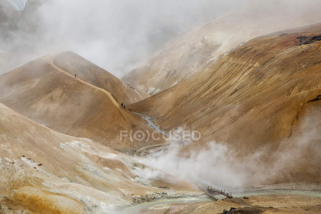 Steam over pond water surrounded by hills — Stock Photo