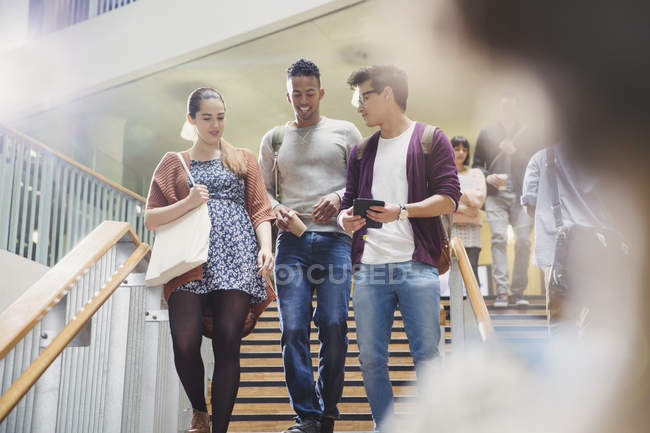 College students talking and descending stairway — Stock Photo