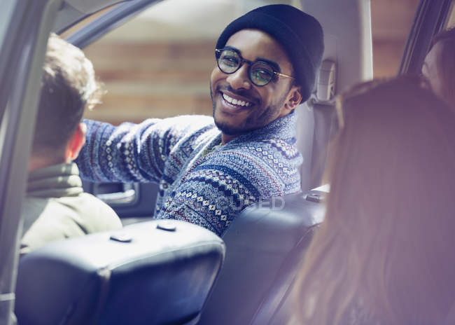 Smiling man riding in car with friends — Stock Photo