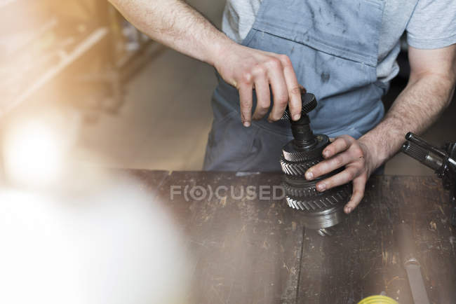 Mécanicien assemblant la pièce de voiture dans l'atelier de réparation automobile — Photo de stock