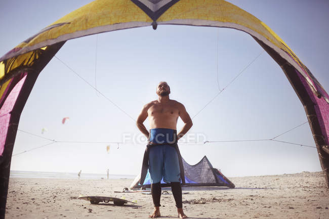 Man preparing to kiteboard on sunny beach — Stock Photo