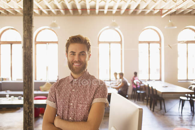 Portrait confident casual businessman in sunny office — Stock Photo