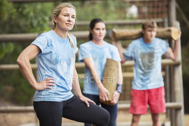 Tired woman resting on boot camp obstacle course — Stock Photo