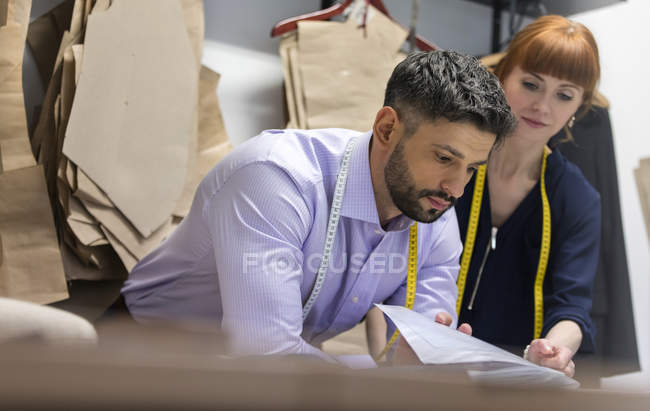 Tailors reviewing patterns in menswear shop — Stock Photo