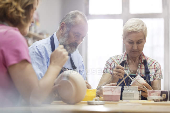 Coppia di anziani che dipinge ceramiche in studio — Foto stock