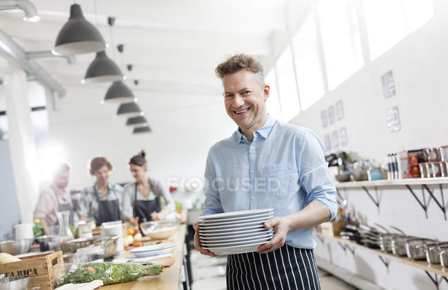 Portrait smiling man in cooking class kitchen — Stock Photo
