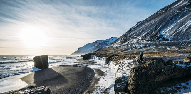 Sol brillando sobre la playa helada y las montañas, Islandia - foto de stock