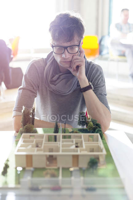 Focused architect viewing model in office — Stock Photo