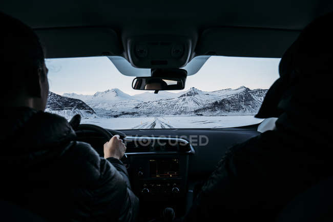 Hommes conduisant une voiture dans un paysage enneigé, Islande — Photo de stock
