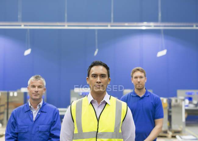 Портрет уверенного менеджера и рабочих сталелитейного завода — стоковое фото