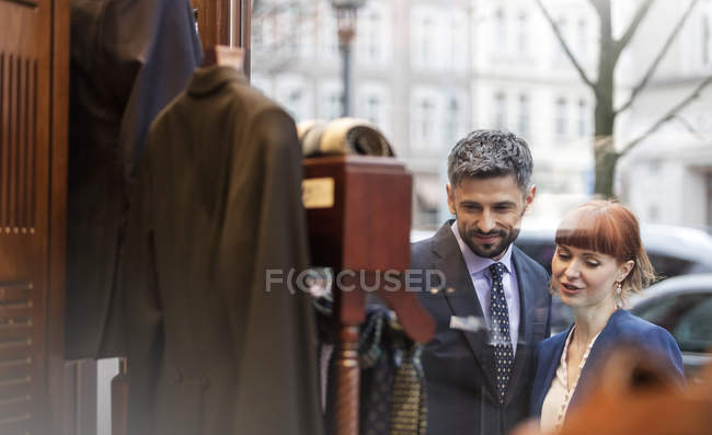 Couple window shopping outside menswear shop — Stock Photo