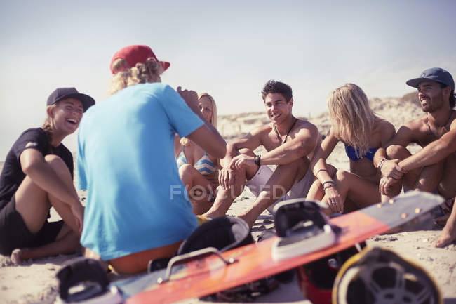 Amigos aprendiendo kitesurf en la playa soleada - foto de stock