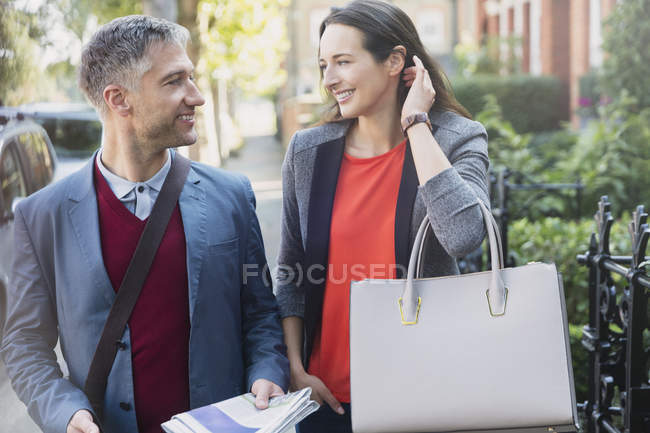 Business couple talking on morning sidewalk — Stock Photo