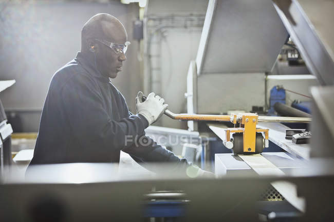 Worker operating machinery in steel factory — Stock Photo