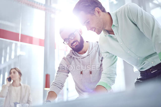 Young businessmen working in sunny office — Stock Photo