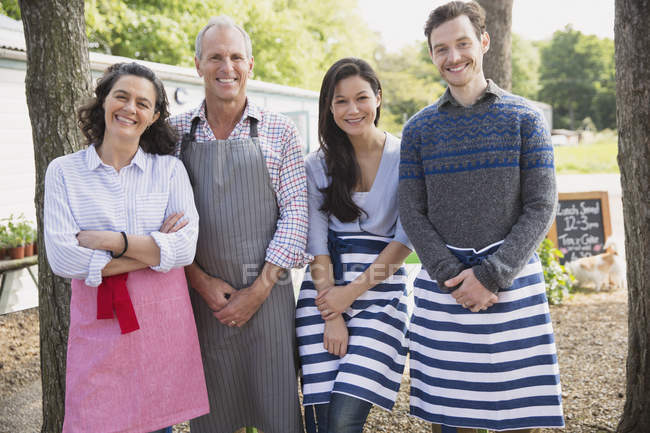 Portrait smiling cafe small business owners wearing aprons — Stock Photo