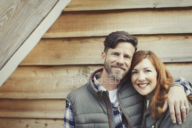 Portrait smiling couple hugging outside cabin — Stock Photo