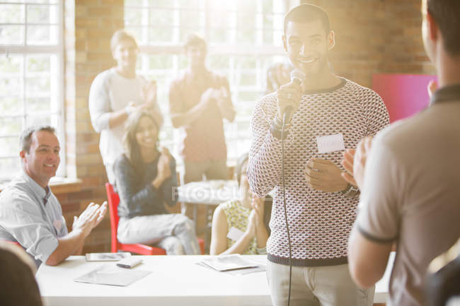 Audience clapping for smiling speaker — Stock Photo