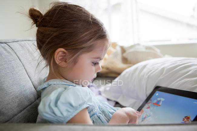 Дівчина використовує цифровий планшет на дивані — стокове фото