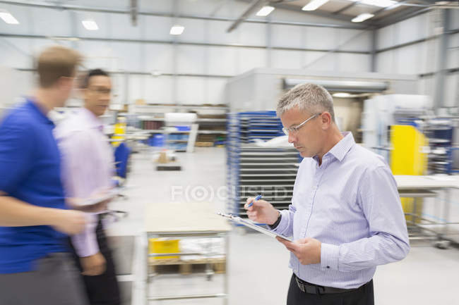 Manager with clipboard in steel industry — Stock Photo