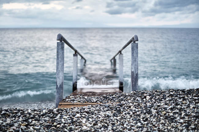 Rampa con ringhiera che conduce nell'oceano, Devon, Regno Unito — Foto stock