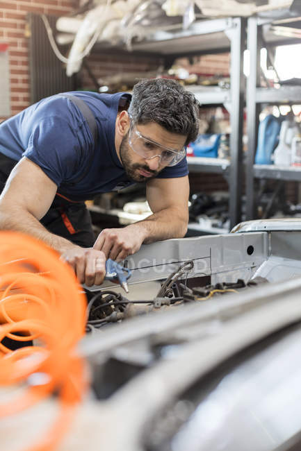 Focused mechanic fixing car in auto repair shop — Stock Photo