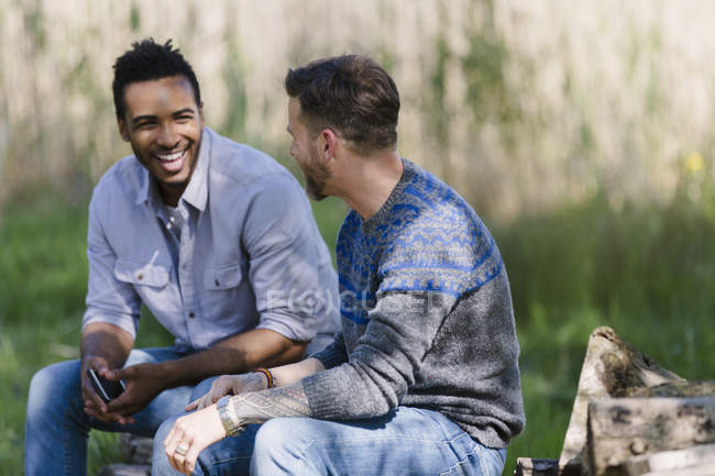 Hombres sonrientes hablando al aire libre - foto de stock