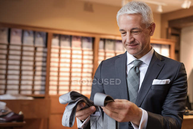 Бизнесмен просматривает галстуки в мужском магазине — стоковое фото