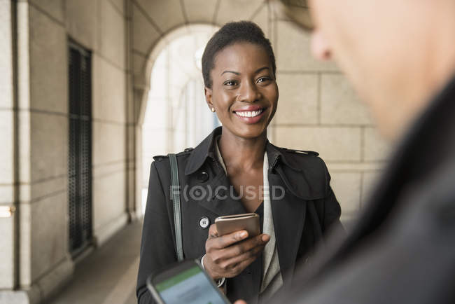 Corporate businessman and businesswoman with cell phones — Stock Photo