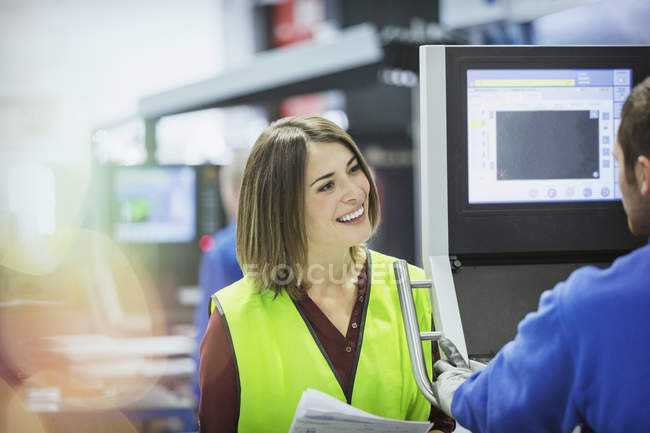 Supervisore sorridente e lavoratore presso il pannello di controllo in acciaieria — Foto stock