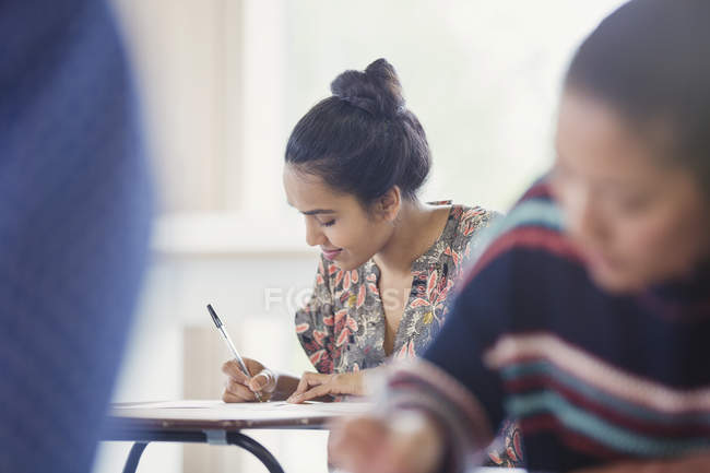 Studentin macht Test am Schreibtisch im Klassenzimmer — Stockfoto