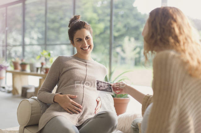 Femmes enceintes partageant une échographie — Photo de stock