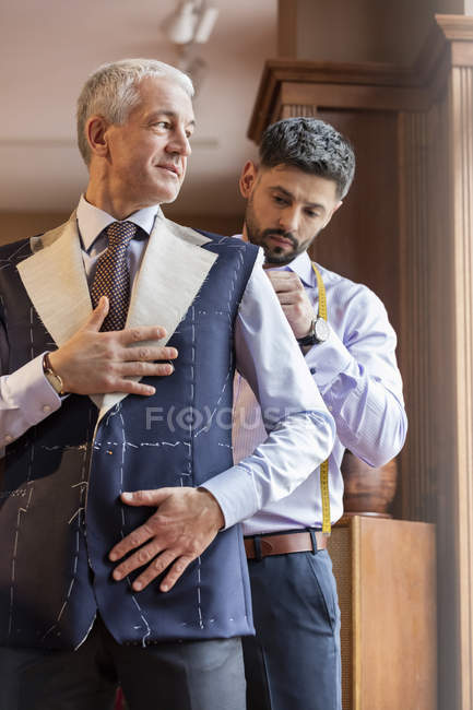 Hombre de negocios a medida para traje en la tienda de ropa de hombre - foto de stock