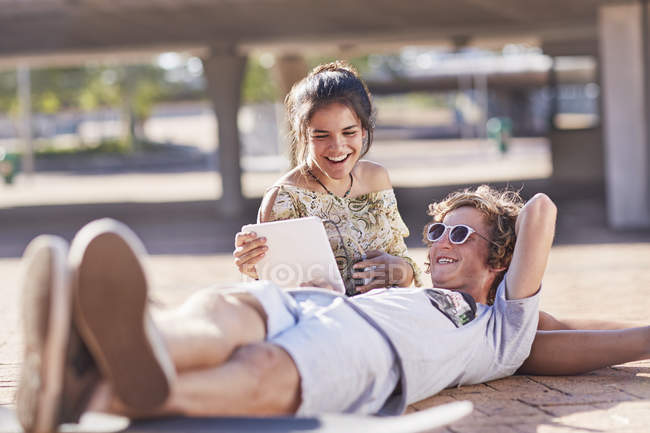 Teenage couple hanging out using digital tablet — Stock Photo