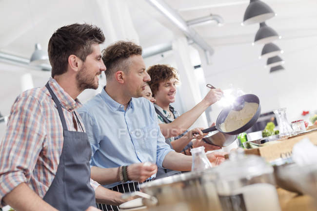 Male students enjoying cooking class in kitchen — Stock Photo