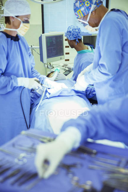 Surgeons performing surgery in operating room — Stock Photo