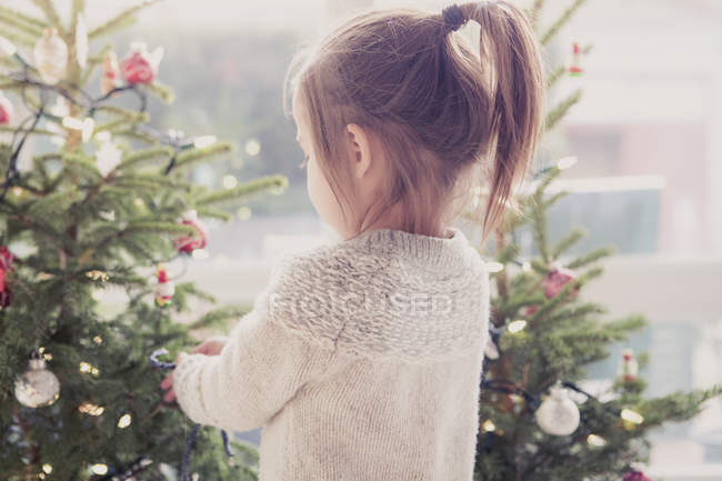 Girl decorating Christmas tree — Stock Photo