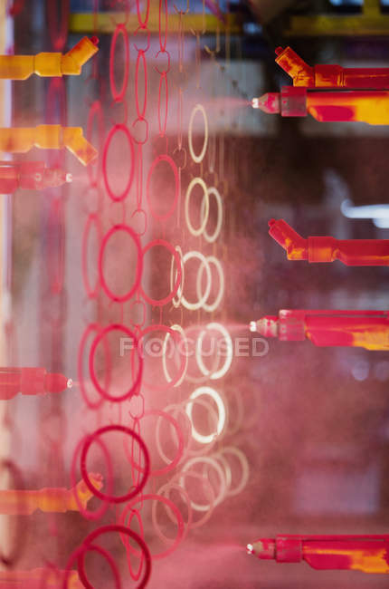 Steel rings being painted red in steel factory — Stock Photo