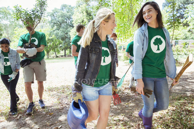 Voluntários ambientalistas sorridentes plantando nova árvore — Fotografia de Stock