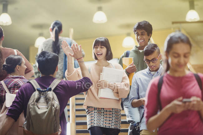 Enthusiastic college students high-fiving in stairway — Stock Photo