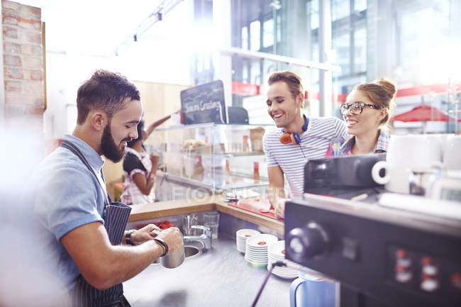 Customers watching barista make coffee in cafe — Stock Photo