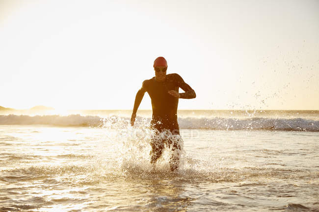 Триатлонист, выбегающий из океана — стоковое фото