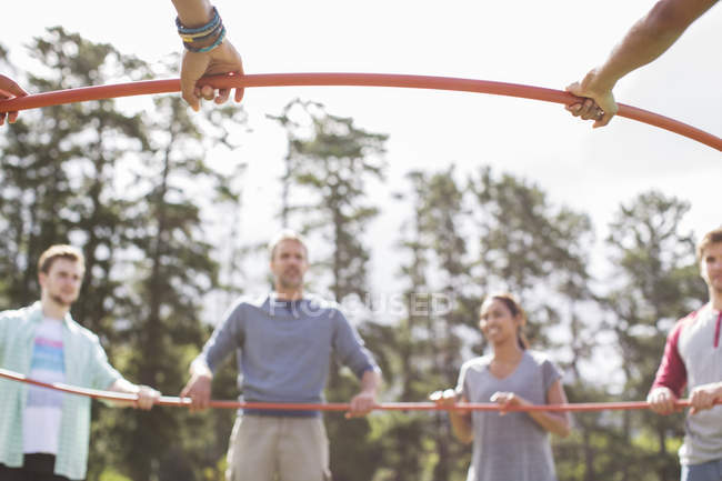 Team connected in circle around plastic hoop — Stock Photo