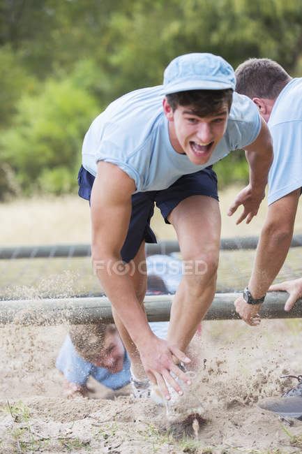 Determined man running on boot camp obstacle course — Stock Photo