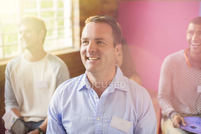 Smiling man in audience indoors — Stock Photo