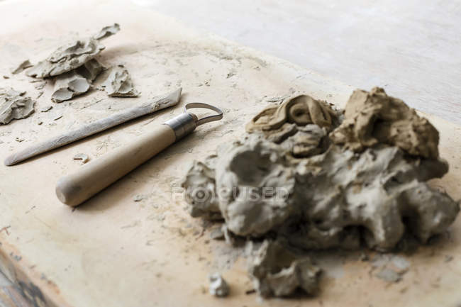 Clay and equipment on board in pottery studio — Stock Photo