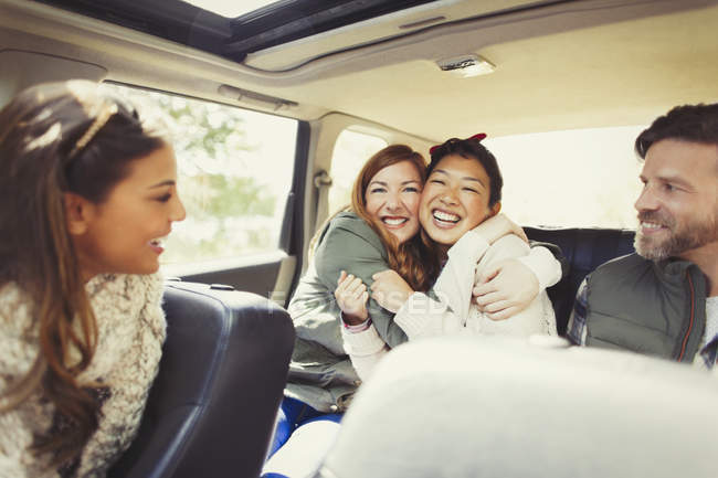 Enthusiastische Freundinnen, die sich auf dem Rücksitz des Autos umarmen — Stockfoto