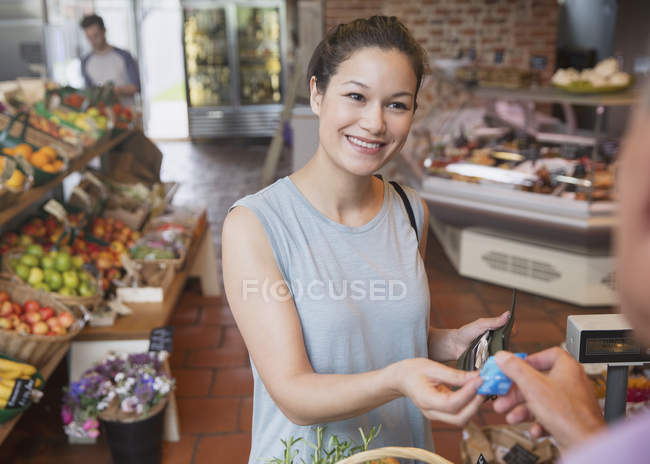 Mulher que paga com cartão de crédito na mercearia checkout — Fotografia de Stock