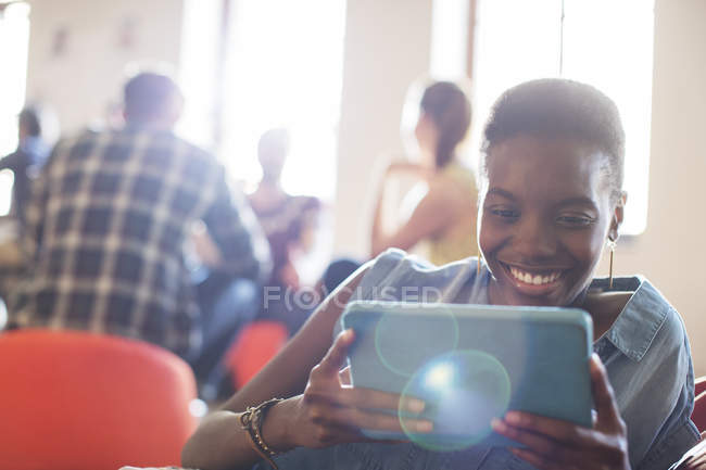 Усміхнена випадкова бізнес-леді, використовуючи цифровий планшет в офісі — стокове фото