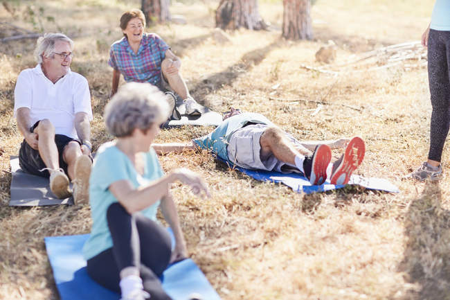 Aînés pratiquant le yoga dans un parc ensoleillé — Photo de stock